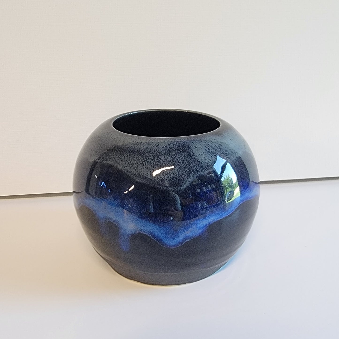 Small round black and blue vase